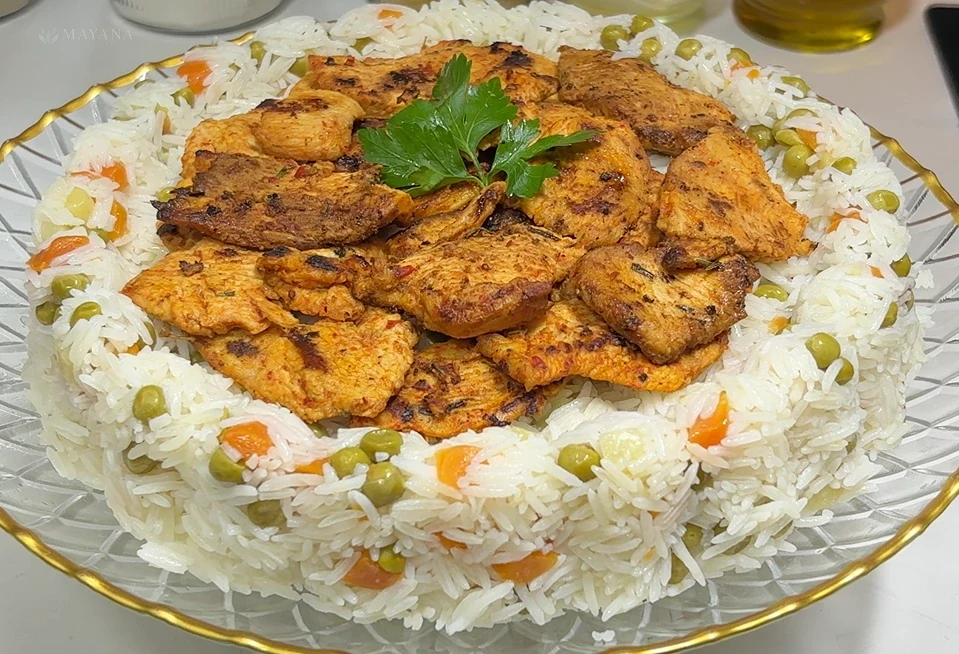 Garnitürlü basmati pilavı üzerinde tavada kızartılmış soslu tavuk dilimleri