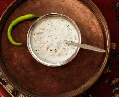 Buğday ve nohut taneleri görünen naneli soğuk ayran aşı çorbası