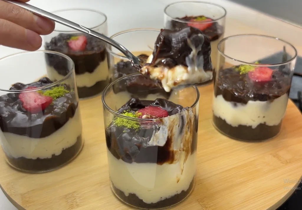 Mısır gevrekli spoonful kasesinde kakaolu kek, sütlü krema ve çikolatalı çıtır katmanlar