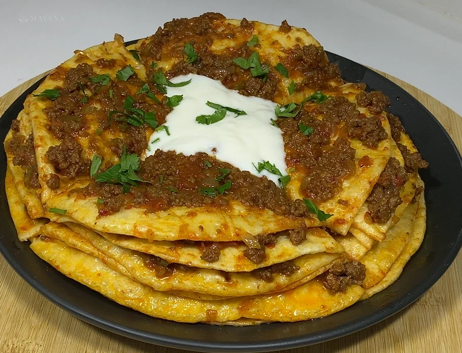 Kat kat şebit ekmekleri arasında kıymalı harç ve yoğurtla servis edilen Kayseri yağlaması