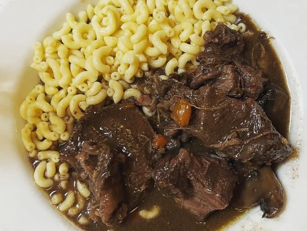 Burgundy-style beef bourguignon with slow-braised beef, mushrooms, and pearl onions in a dark sauce