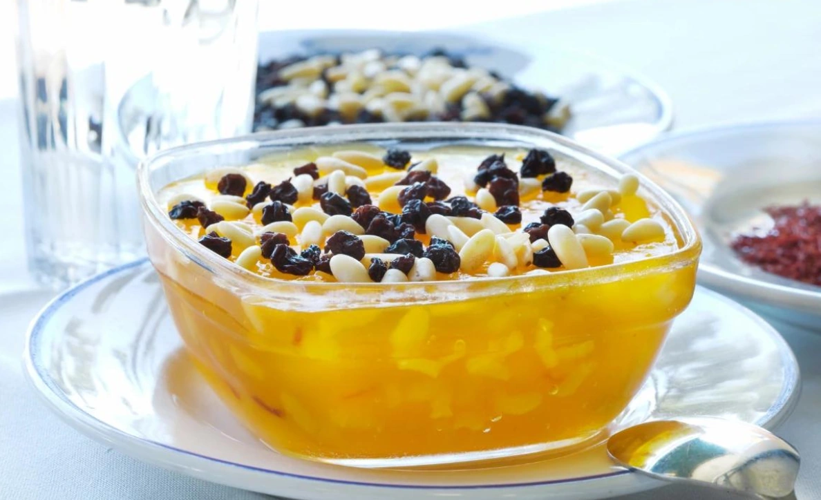 Zerde with yellow saffron-colored rice, topped with pistachios and pomegranate seeds